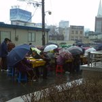 비맞으며 식사하시는 무료급식자들